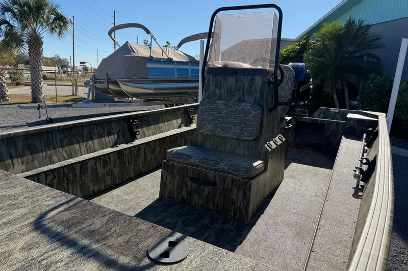 Slide: The Image of 2026 Smoker Craft Sportsman 1866 boat with camouflage interior, parked outdoors. - 9