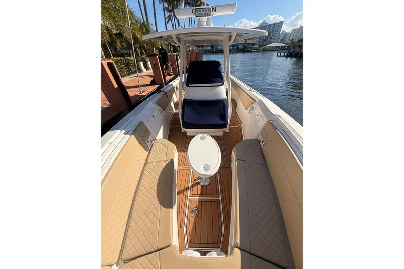 Slide: The Image of 2019 Intrepid 345 Nomad FE boat interior with tan seating and wooden deck. - 14