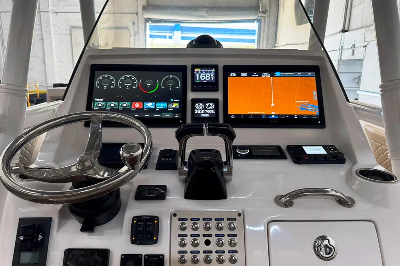 Slide: The Image of 2019 Intrepid 345 Nomad FE boat dashboard with navigation screens and controls. - 2