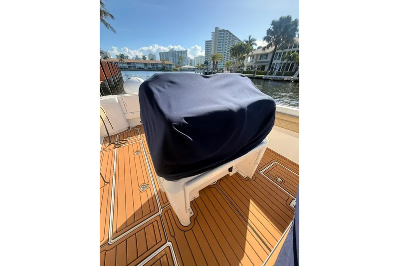 Slide: The Image of 2019 Intrepid 345 Nomad FE boat with covered seating, docked near waterfront buildings. - 26
