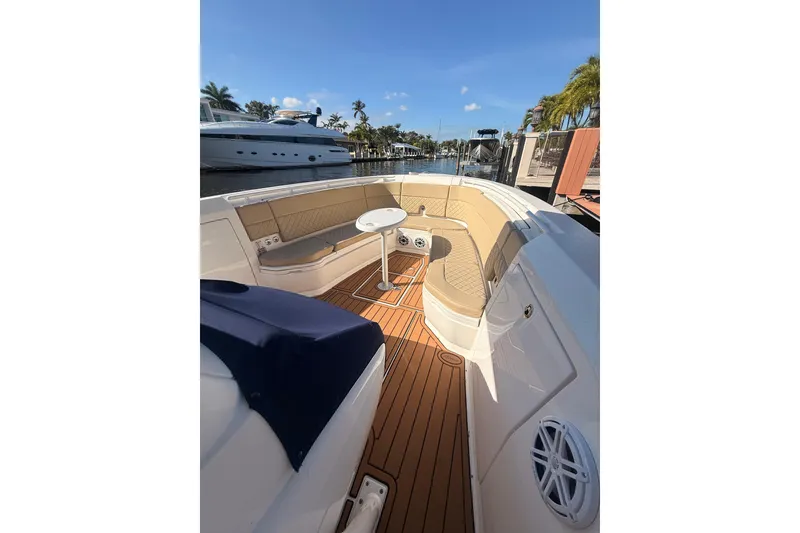 Slide: The Image of 2019 Intrepid 345 Nomad FE boat with elegant seating and teak flooring, docked under clear skies. - 27