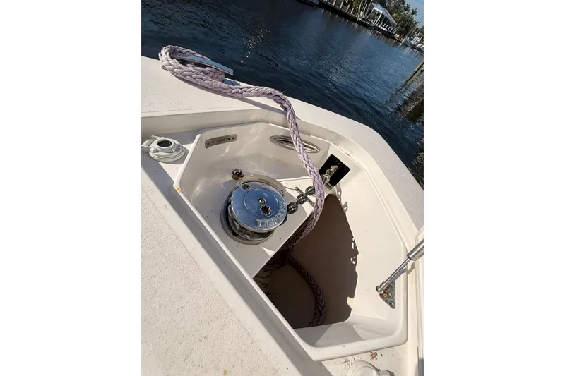 Slide: The Image of 2019 Intrepid 345 Nomad FE boat anchor compartment with rope and winch by the water. - 31