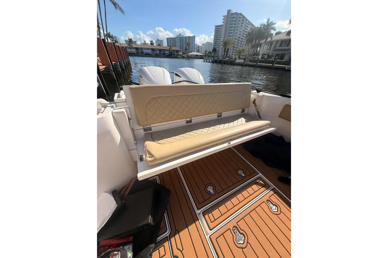 Slide: The Image of 2019 Intrepid 345 Nomad FE boat interior with tan seating and wooden deck. - 32