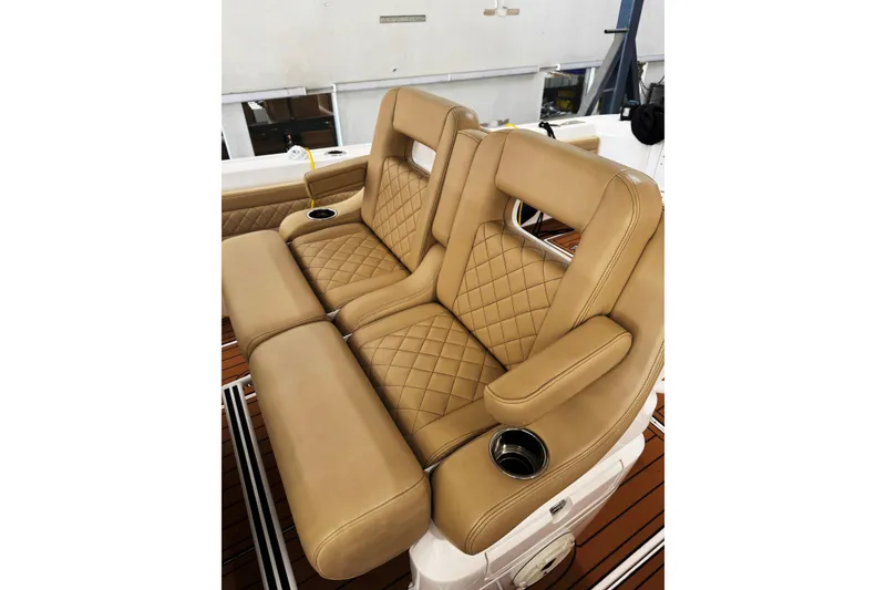 Slide: The Image of Luxurious tan leather seating on 2019 Intrepid 345 Nomad FE boat, featuring diamond stitching and cup holders. - 4