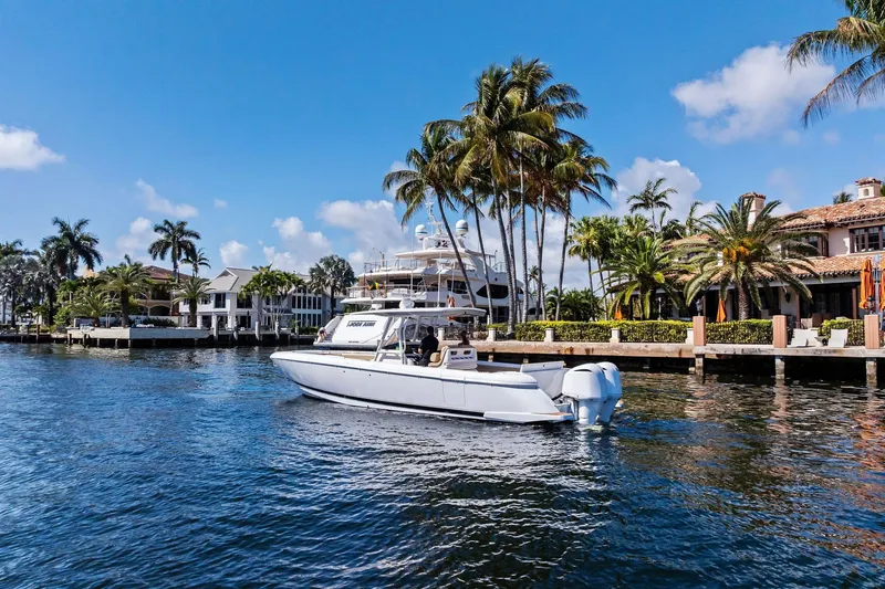 Slide: The Image of 2019 Intrepid 345 Nomad FE boat with open storage compartment, dockside view. - 40