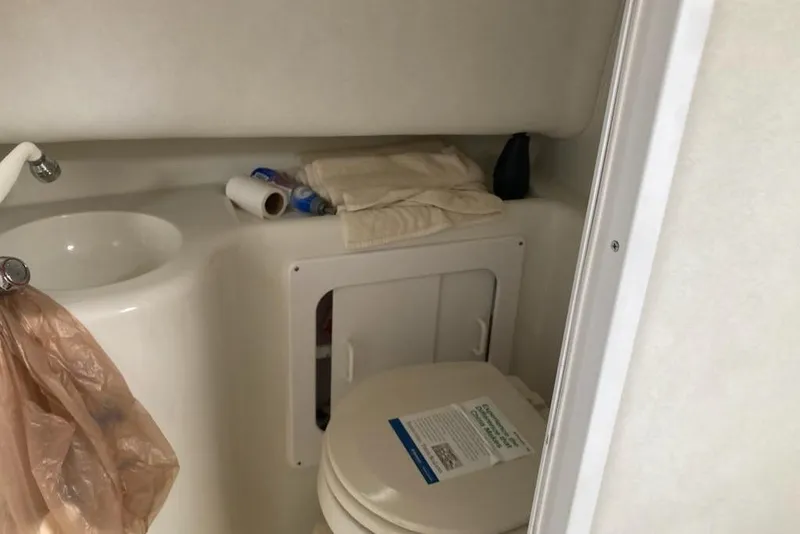 Slide: The Image of 2005 Pro-Line 30 Walkaround boat bathroom with sink, toilet, and storage area. - 12
