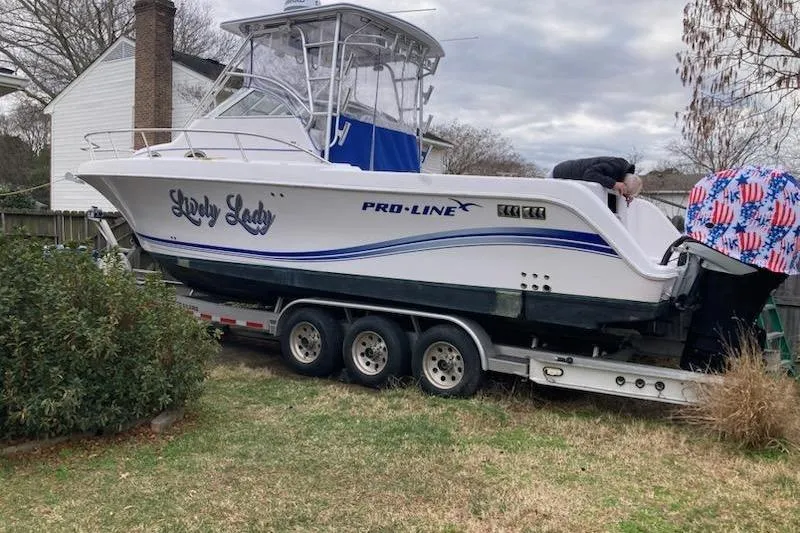 Slide: The Image of 2005 Pro-Line 31 Sport boat on trailer in residential yard. - 4