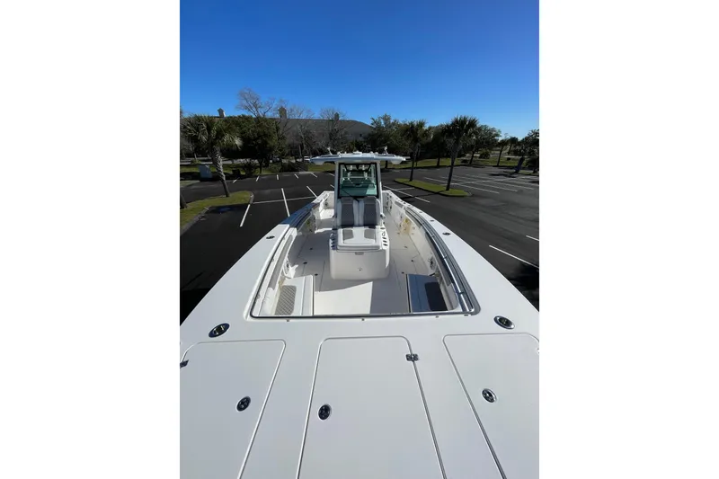 Slide: The Image of 2024 Caymas 34 CT boat in a parking lot, showcasing sleek design and spacious deck. - 12