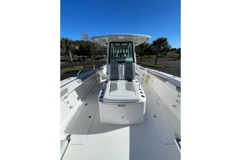 Slide: The Image of 2024 Caymas 34 CT boat interior with seating and console, under clear blue sky. - 13