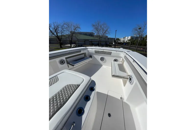 Slide: The Image of 2024 Caymas 34 CT boat interior with cushioned seating and speakers under clear blue sky. - 14