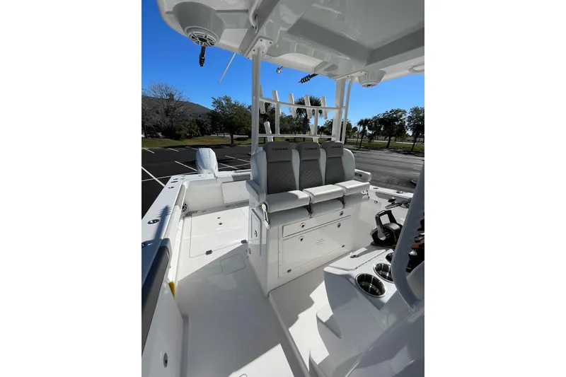 Slide: The Image of 2024 Caymas 34 CT boat interior with seating and console, parked outdoors. - 17