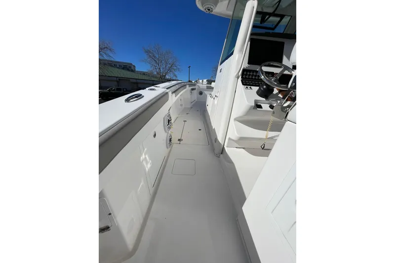 Slide: The Image of 2024 Caymas 34 CT boat deck with steering wheel and controls under clear blue sky. - 20