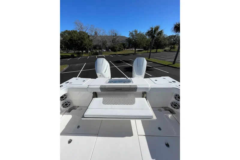 Slide: The Image of 2024 Caymas 34 CT boat with dual engines, parked in a sunny lot. - 23