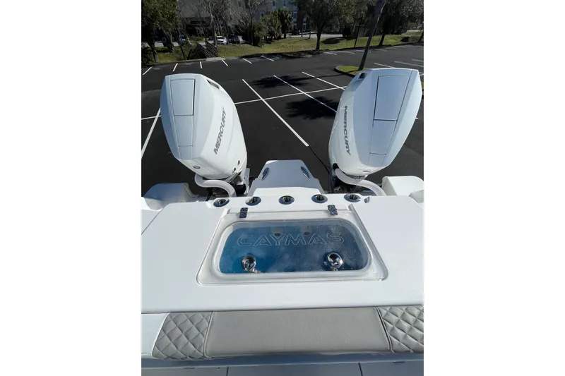 Slide: The Image of 2024 Caymas 34 CT boat with dual Mercury outboard engines in a parking lot. - 24