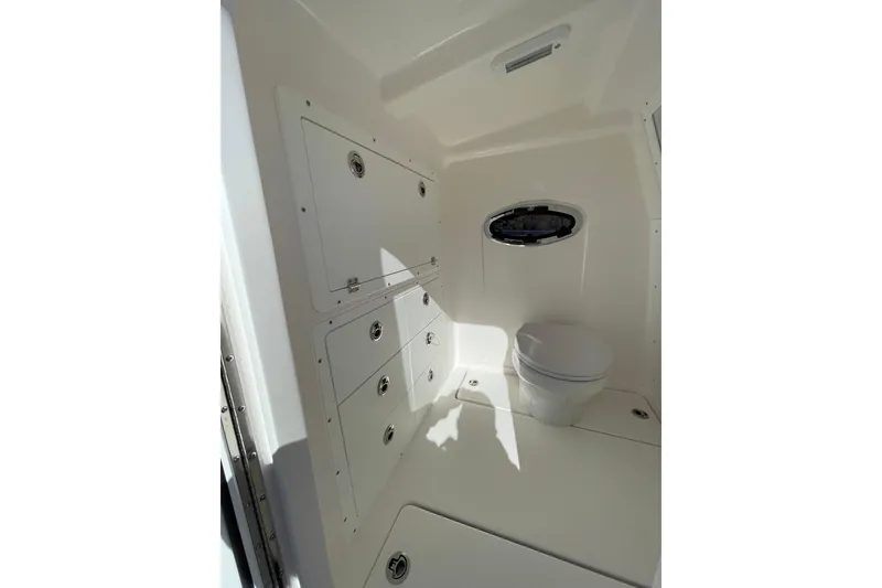 Slide: The Image of 2024 Caymas 34 CT boat interior bathroom with storage cabinets and toilet. - 29