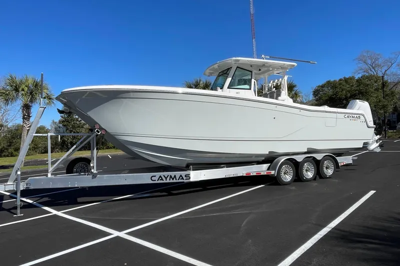 Slide: The Image of 2024 Caymas 34 CT boat on trailer in parking lot under clear blue sky. - 7