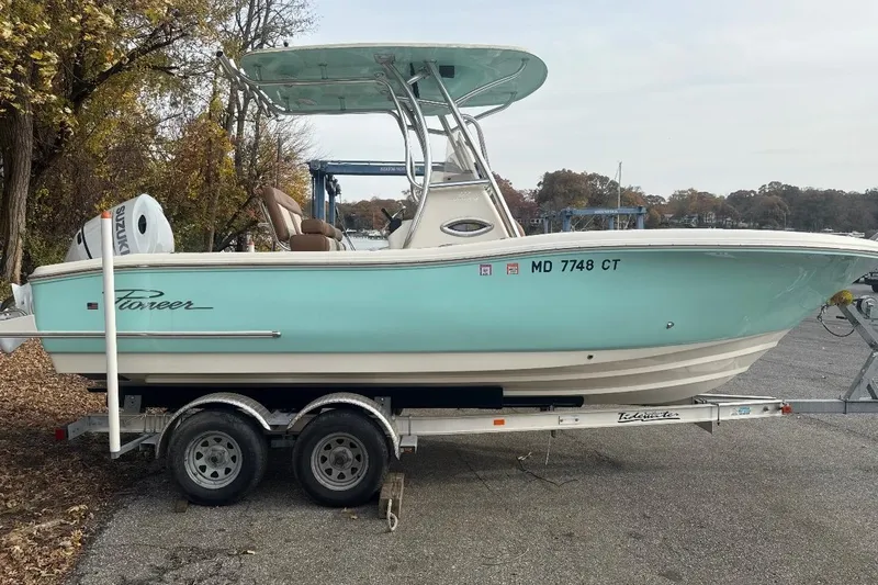 Slide: The Image of 2021 Pioneer 222 Sportfish boat on trailer, light blue hull, parked outdoors. - 1