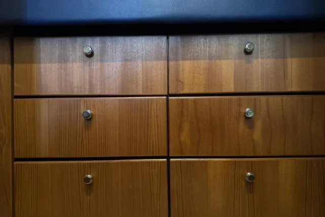 Slide: The Image of Wooden cabinetry on a 1995 Bayliner 3988 Motoryacht, featuring sleek metal knobs. - 17