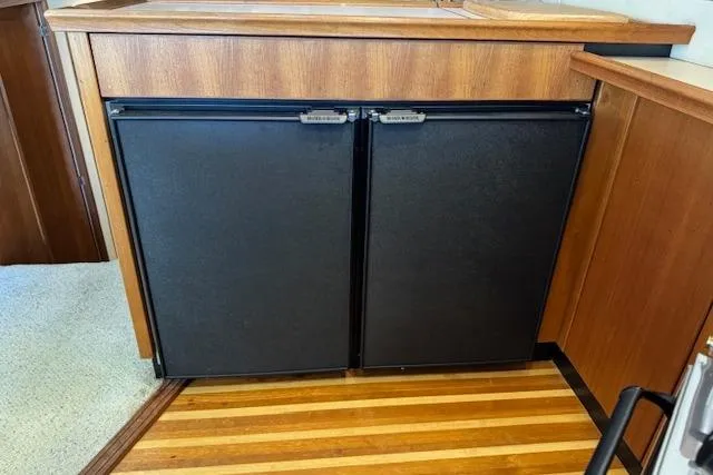 Slide: The Image of 1995 Bayliner 3988 Motoryacht interior with dual black cabinet doors and wood paneling. - 7