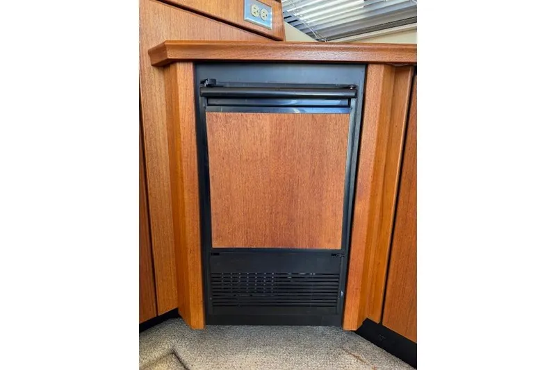 Slide: The Image of 1995 Bayliner 3988 Motoryacht interior with wood-paneled mini fridge. - 8