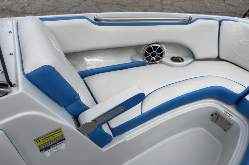 Slide: The Image of 2026 Crownline 220 SS boat interior with blue and white seating, speaker, and cup holder. - 10