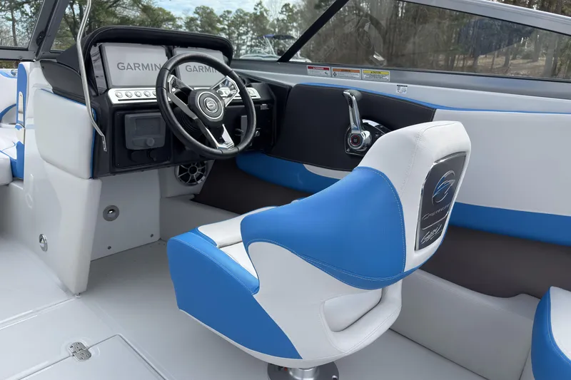 Slide: The Image of 2026 Crownline 220 SS boat interior with blue and white seating, steering wheel, and Garmin displays. - 15