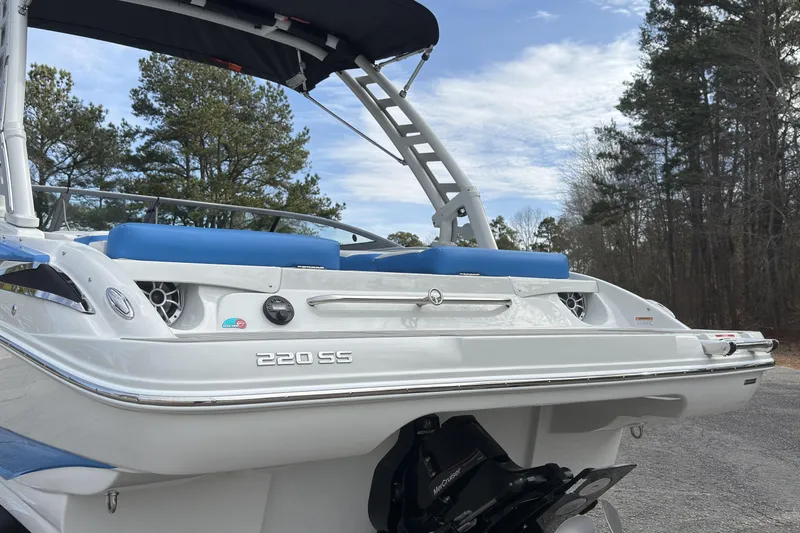 Slide: The Image of 2026 Crownline 220 SS boat with blue seating, parked outdoors. - 17