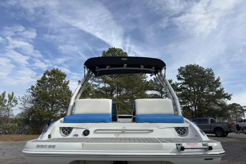 Slide: The Image of 2026 Crownline 220 SS boat with blue and white seating, parked outdoors under a cloudy sky. - 4