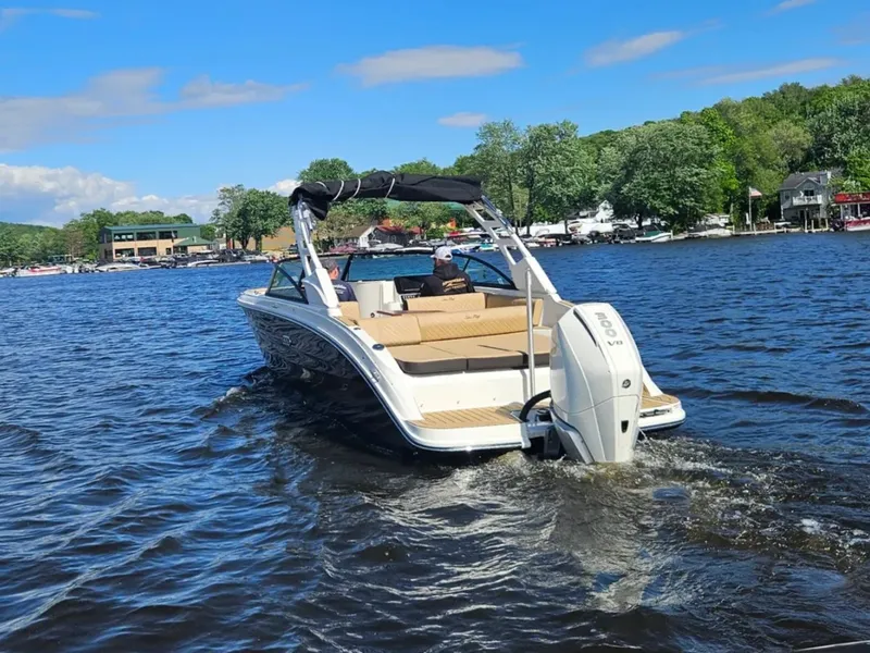 Slide: The Image of A 2026 Sea Ray SDX 270 Outboard cruising on a calm lake with wooded shoreline. - 4