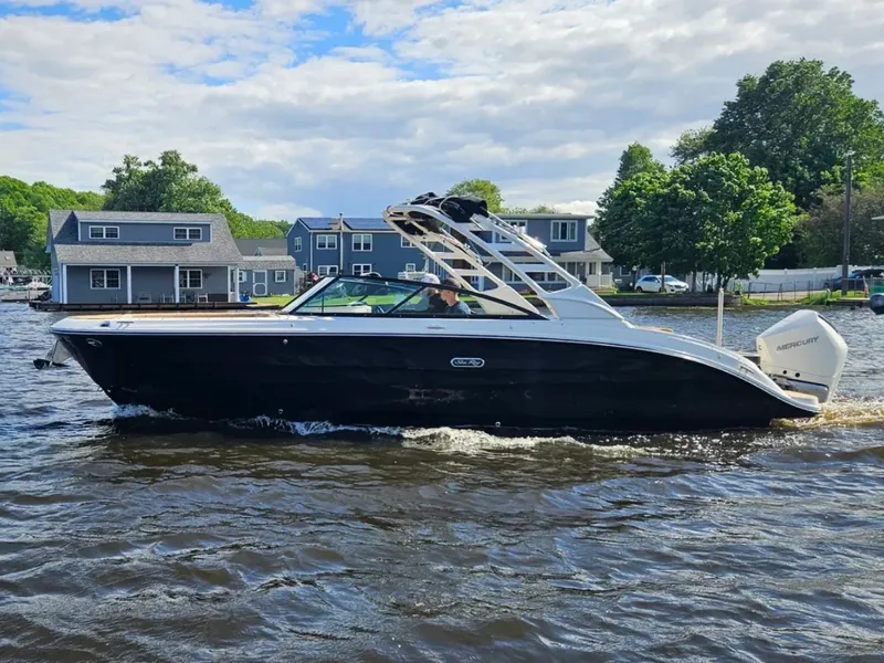 Slide: The Image of A sleek, modern boat cruising on a river, surrounded by houses and trees. - 1