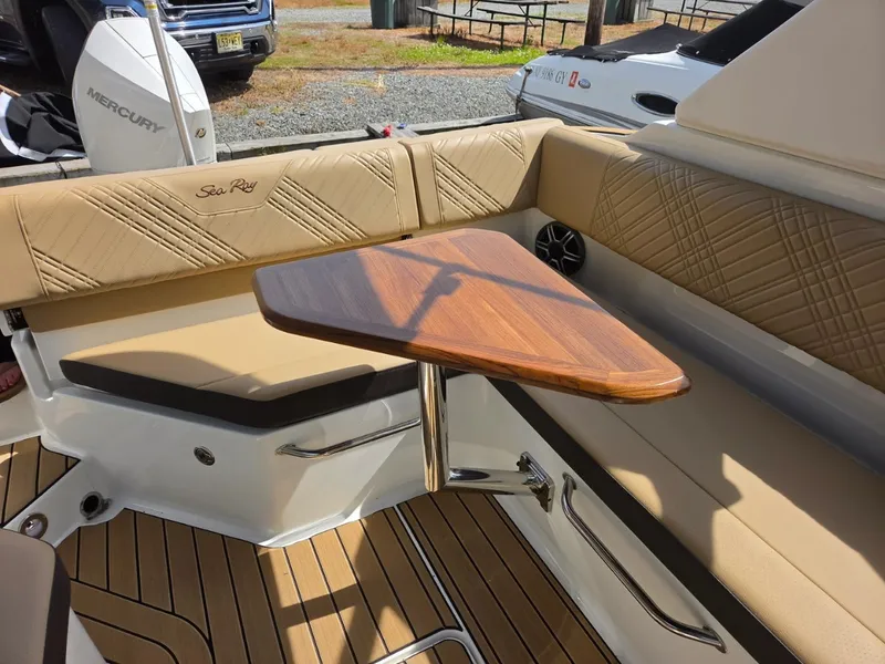 Slide: The Image of The image shows the seating area of a Sea Ray SDX 270 Outboard with a wooden table. - 9