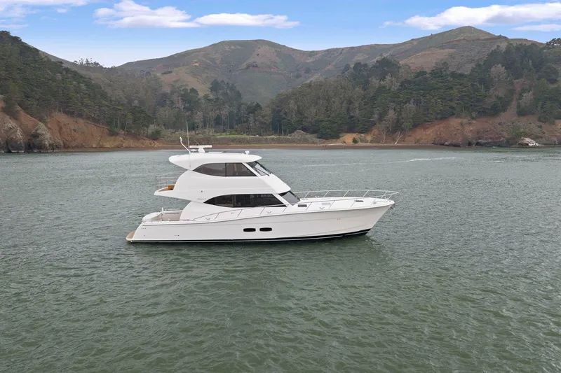 Slide: The Image of 2014 Maritimo M50 yacht cruising on a scenic lake with mountainous backdrop. - 4