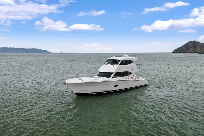 Slide: The Image of 2014 Maritimo M50 yacht cruising on open water under a clear blue sky. - 7