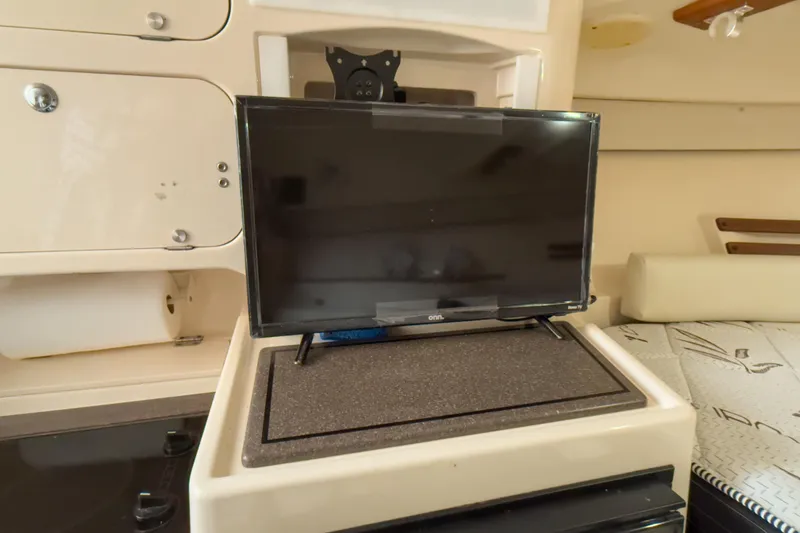 Slide: The Image of 2006 Grady-White Express 330 cabin interior with TV and storage compartments. - 11