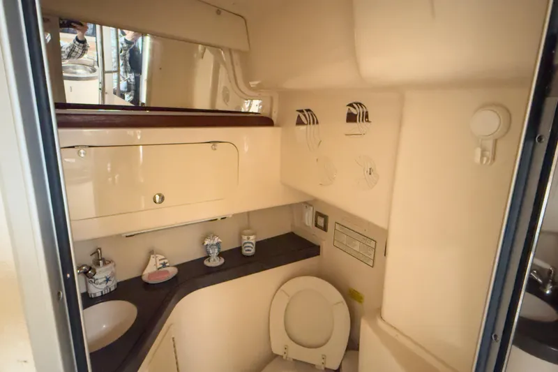 Slide: The Image of 2006 Grady-White Express 330 boat bathroom with sink, toilet, and storage cabinet. - 15