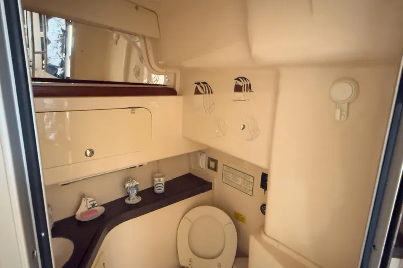 Slide: The Image of 2006 Grady-White Express 330 boat bathroom interior with toilet and storage cabinets. - 16