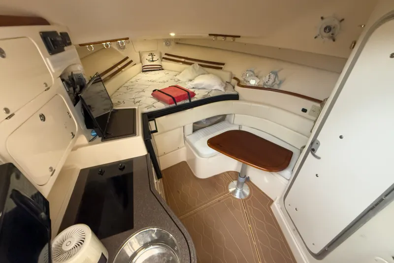Slide: The Image of 2006 Grady-White Express 330 cabin interior with kitchenette, seating, and sleeping area. - 25