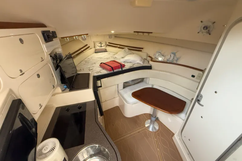Slide: The Image of 2006 Grady-White Express 330 cabin interior with kitchenette and cozy seating area. - 26