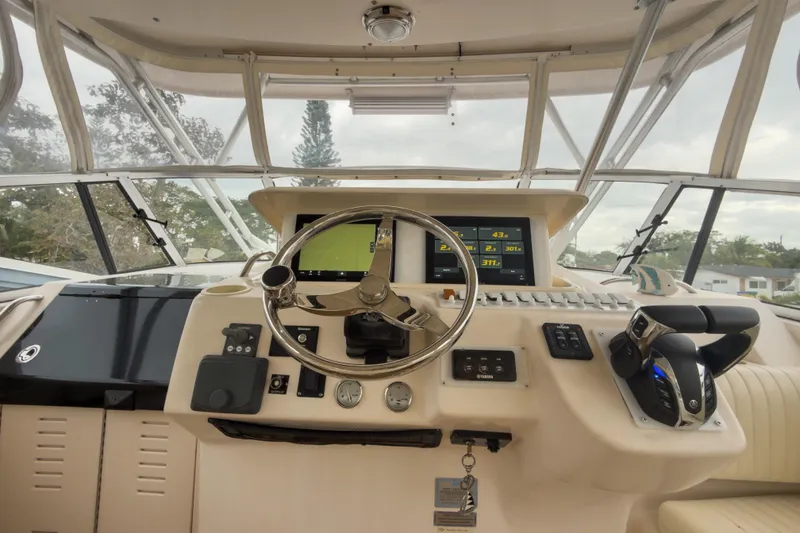 Slide: The Image of Helm of 2006 Grady-White Express 330 boat with steering wheel and navigation controls. - 38
