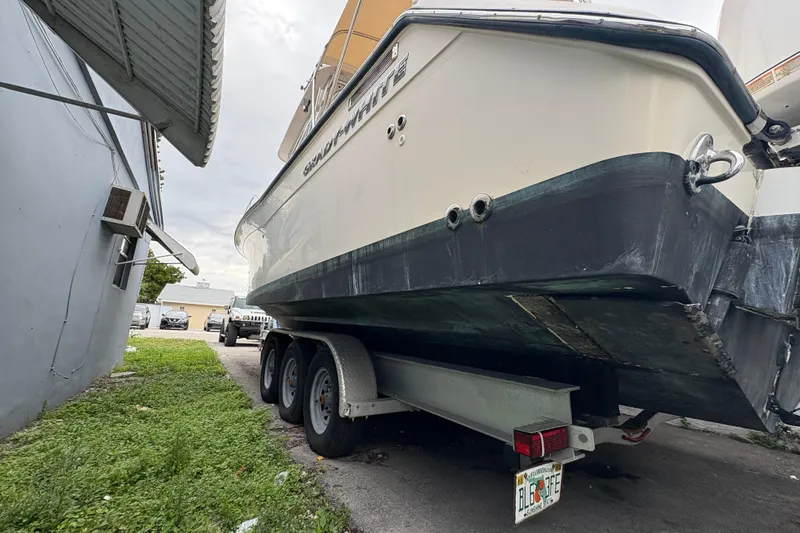 Slide: The Image of 2006 Grady-White Express 330 boat on trailer, parked beside a building. - 7