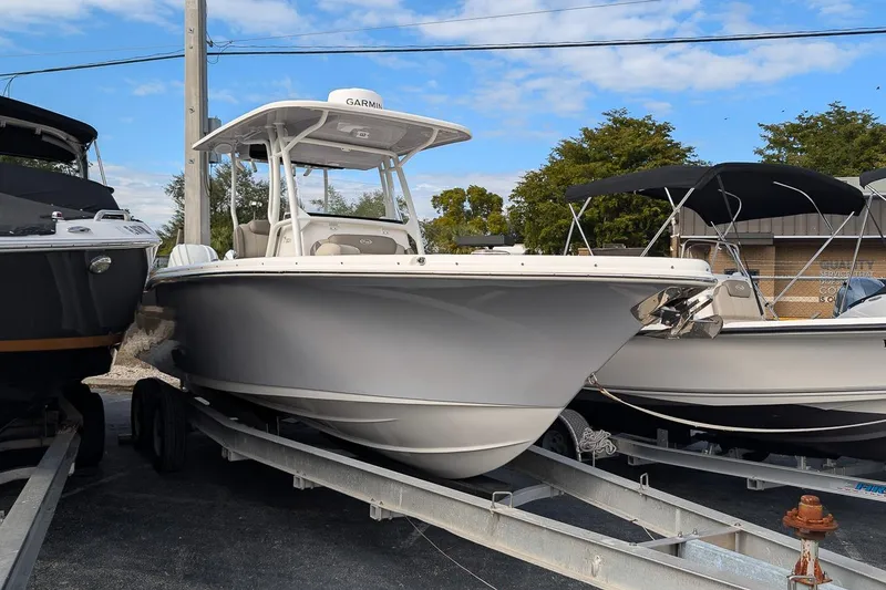 The Image of 2023 Key West 263 FS boat on trailer, parked outdoors under blue sky. - 0