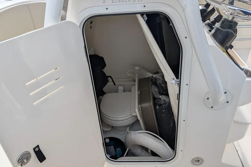 Slide: The Image of 2023 Key West 263 FS boat interior storage compartment with toilet and accessories. - 18