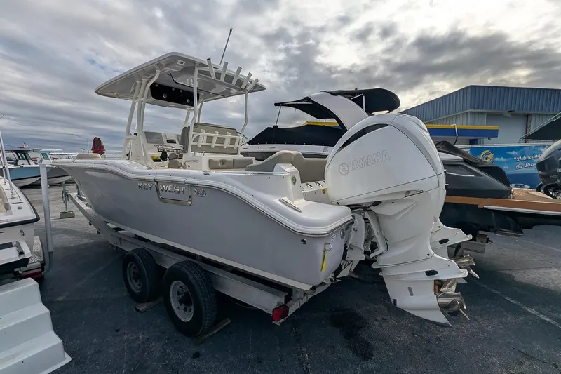 Slide: The Image of 2023 Key West 263 FS boat with Yamaha engine on trailer, parked outdoors. - 2