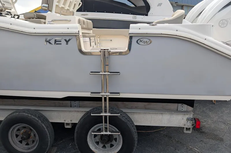 Slide: The Image of 2023 Key West 263 FS boat on trailer, featuring side ladder and seating area. - 7