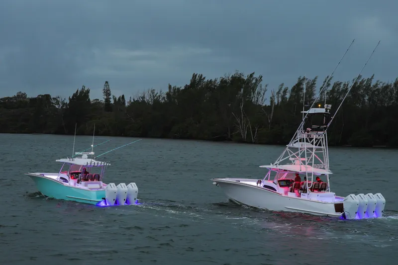 Slide: The Image of 2026 Mag Bay 43 CC boats cruising on a serene waterway at dusk. - 21