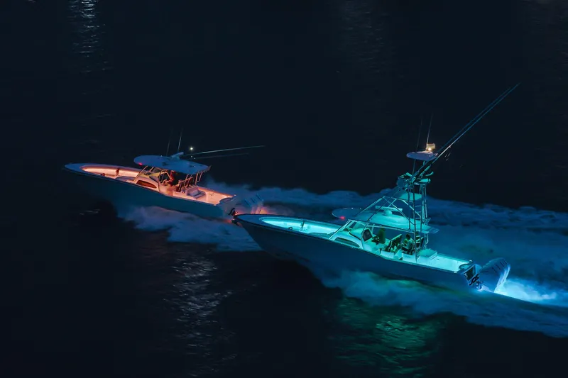 Slide: The Image of Two illuminated Mag Bay 43 CC boats cruising at night, 2026 model. - 22