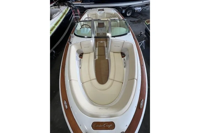 Slide: The Image of 2011 Chris-Craft Launch 22 boat with elegant seating and wooden accents in a showroom. - 20