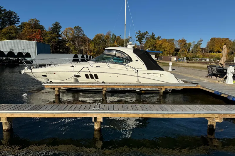 Slide: The Image of 2006 Sea Ray 38 Sundancer yacht docked at a marina with autumn trees. - 1