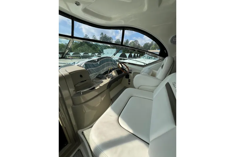 Slide: The Image of 2006 Sea Ray 38 Sundancer cockpit with white seating and modern controls. - 11