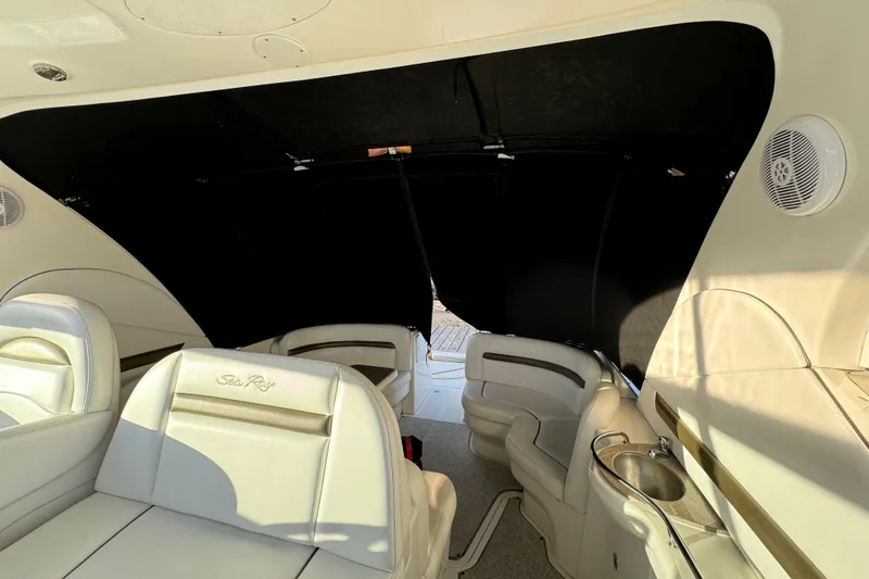 Slide: The Image of Interior of 2006 Sea Ray 38 Sundancer yacht with white seating and black canopy. - 13